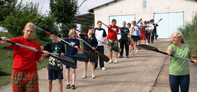 Foto: In einer Reihe stehende Schüler üben den Paddelschlag.