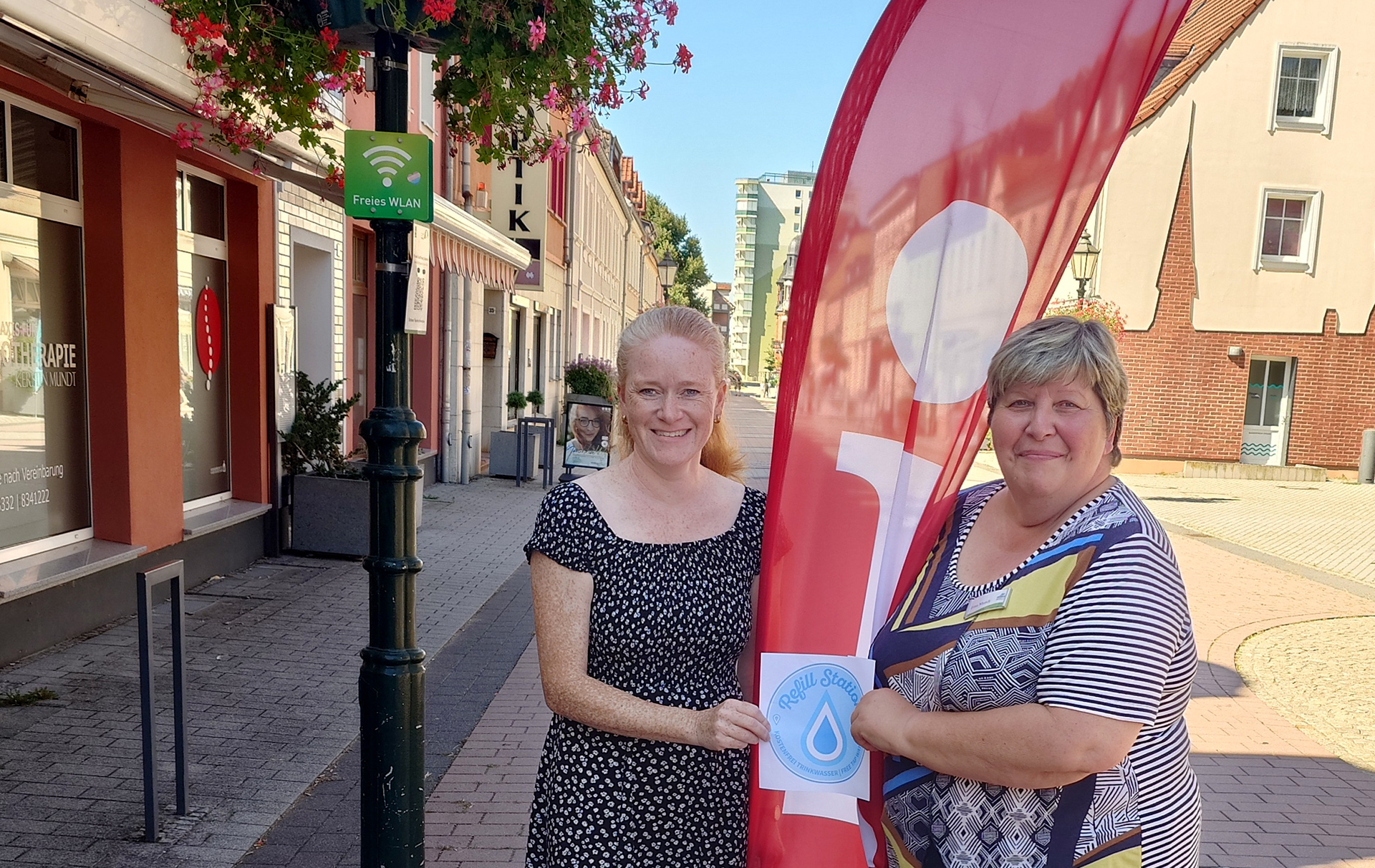 Foto: 2 Frauen den Aufkleber in der Vierradener Straße