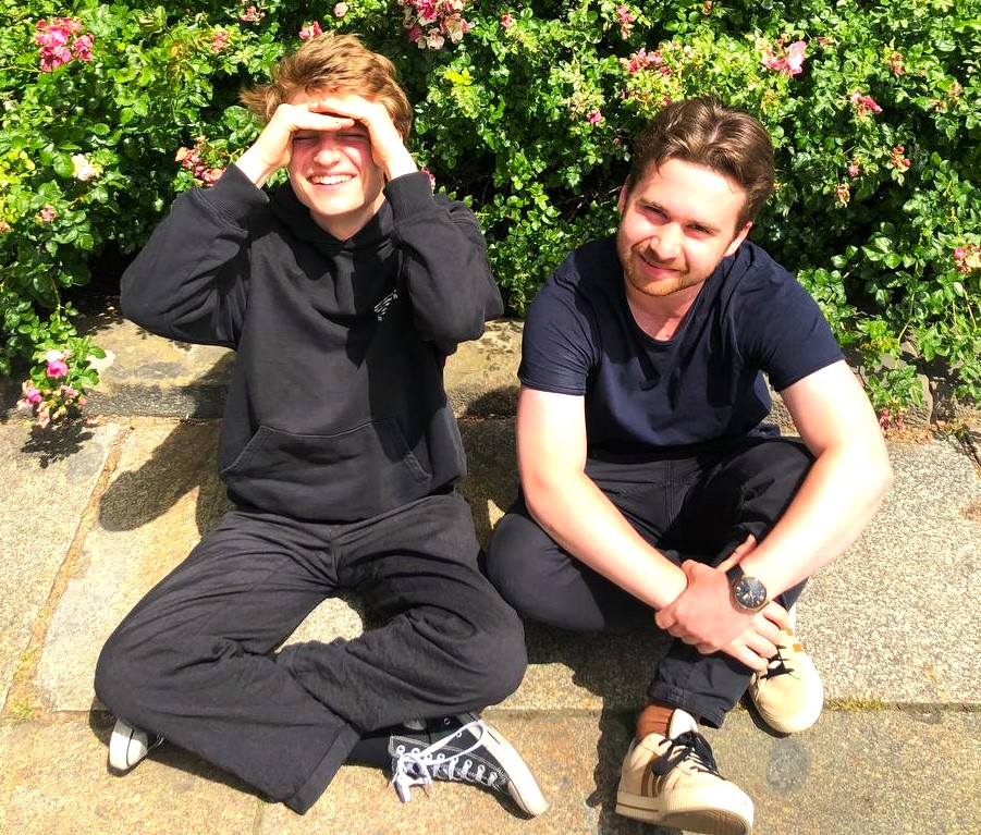 Foto: 2 junge Männer sitzen auf dem Boden