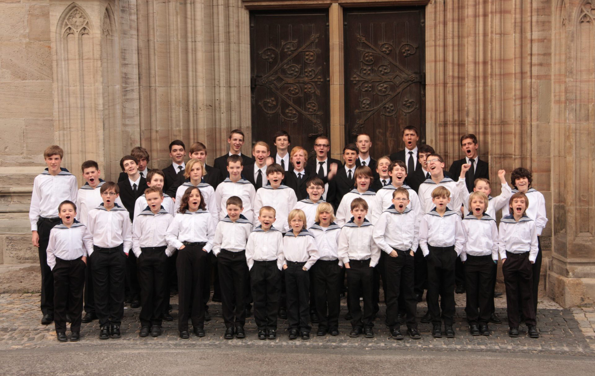 Foto: Knabenchor vor einem Kirchenportal Foto: Knabenchor vor einem Kirchenportal