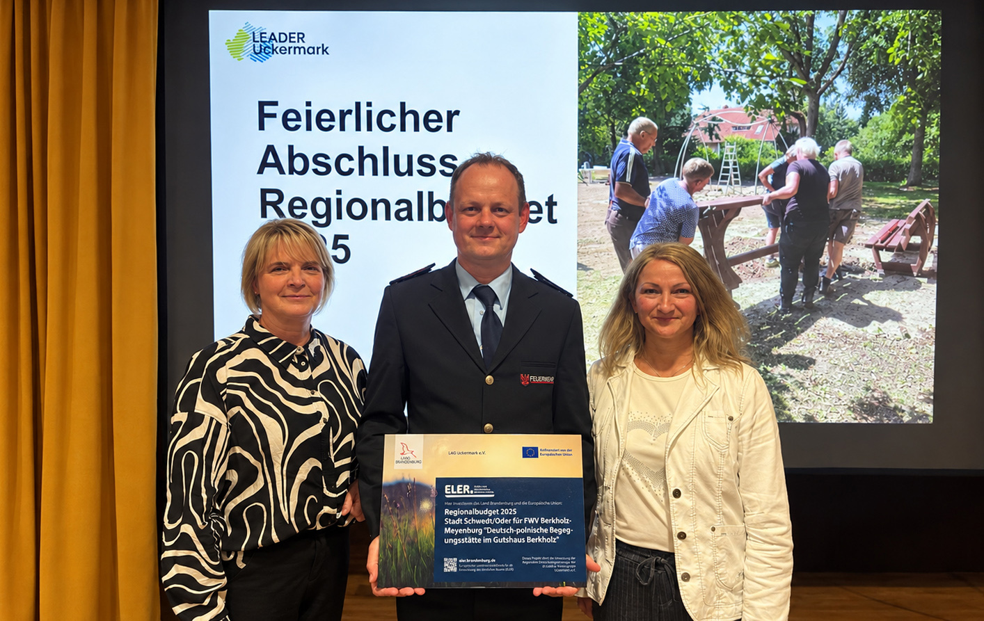 Foto: 3 Personen mit Tafel