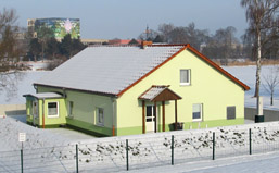 Foto: Anglerheim im Winter, im Hintergrund der Bühnenturm der Uckermärkischen Bühnen