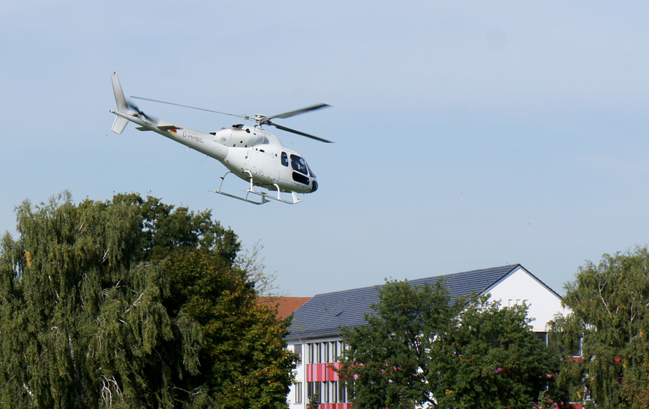 Foto: weißer Hubschrauber über dem Haus der Bildung und Technologie