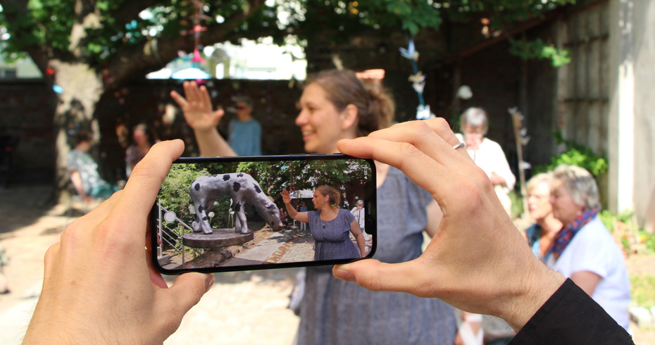 Foto: Frau streichelt die nur virtuell  vorhandene, auf dem Handy in der App zu sehende Plastik