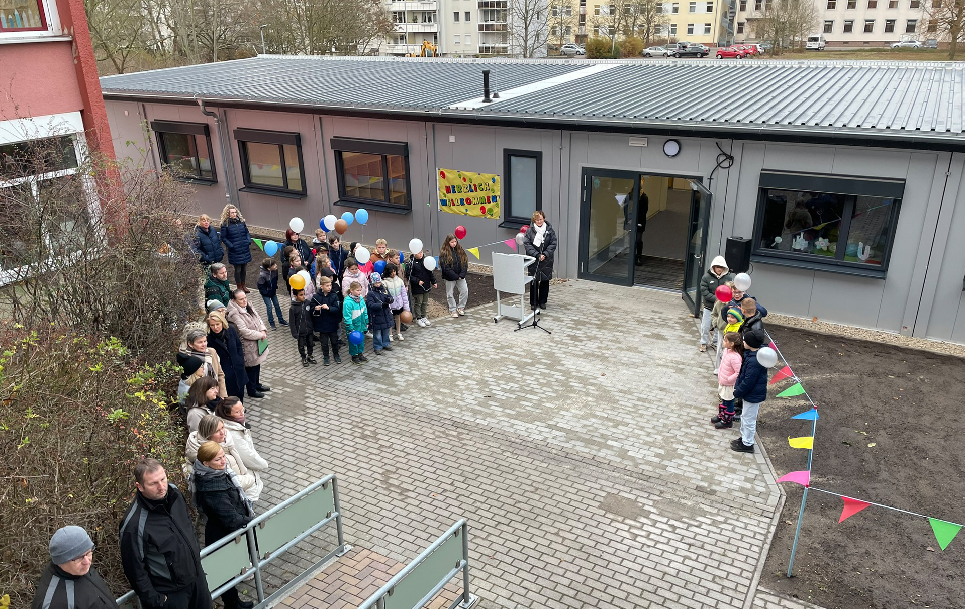 Foto: Schüler, Gäste und Offizielle vor dem Eingang des neuen Baus