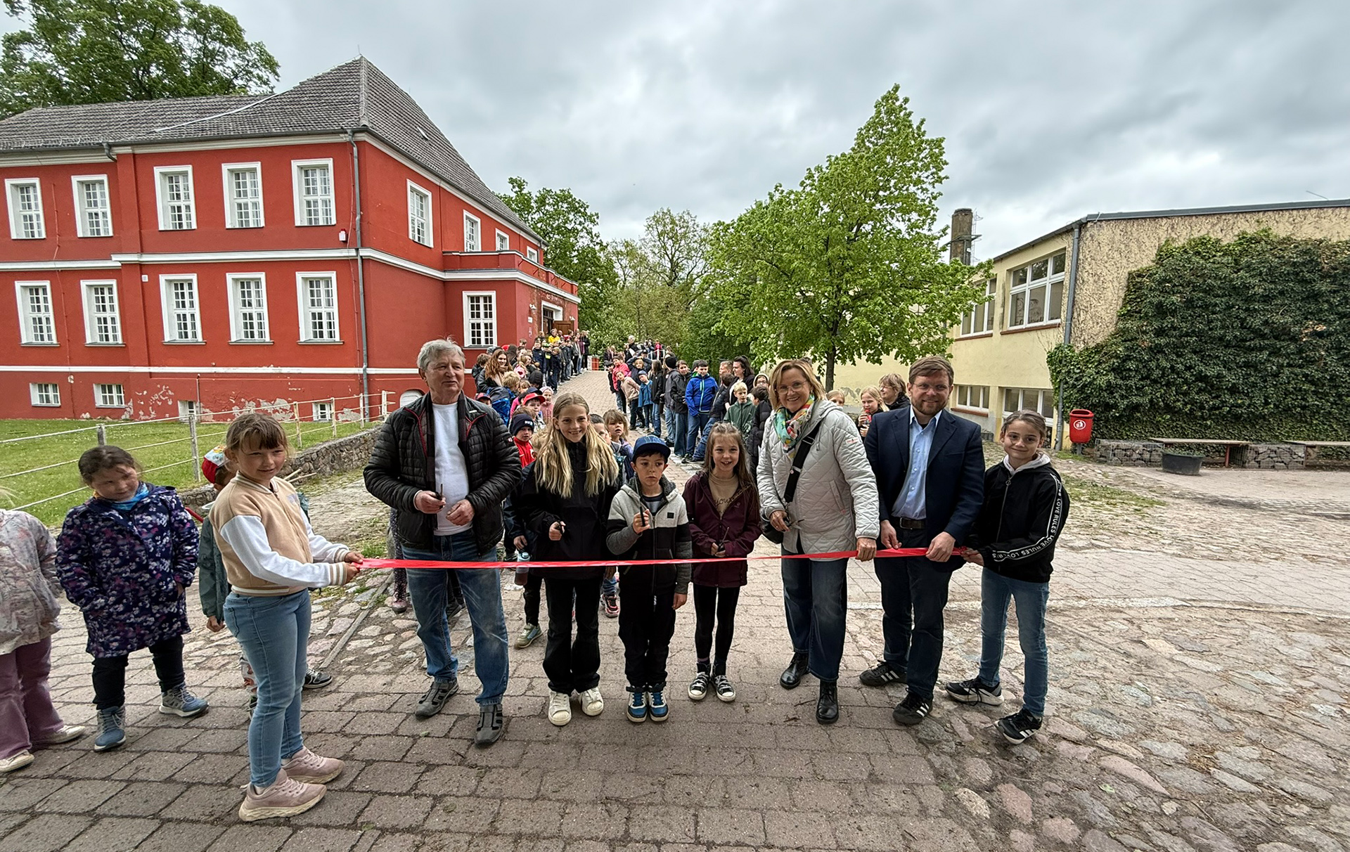 Foto: Banddurchschnitt mit Offiziellen und Schülern