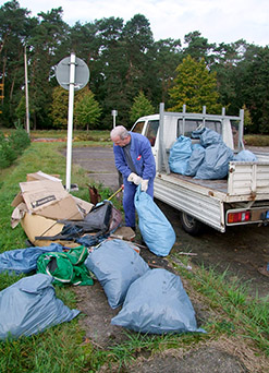 Foto: Stadtarbeiter wirft Müllsäcke auf einen Transporter.