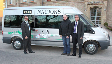 Foto: 3 Herren vor dem Taxi mit dem Storchenaufkleber