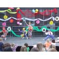 Foto: Kinder in Clownskostümen tanzen auf der Bühne.