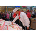 Foto: Konditor Schäpe schneidet die riesige Torte an.