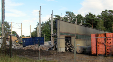 Foto: freistehende Wand der Sporthalle und Container