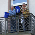 Foto: 2 Männer mit blauen Eimern beim Ausschütten