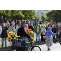 Foto: Mann mit blumenbeschmückten Fahrrad und Publikum