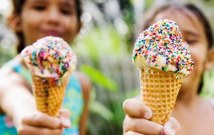 Foto: 2 Mädchen halten ihre Eiswaffeln mit Zuckerperlen vor sich ins Bild. Foto: 2 Mädchen halten ihre Eiswaffeln mit Zuckerperlen vor sich ins Bild.