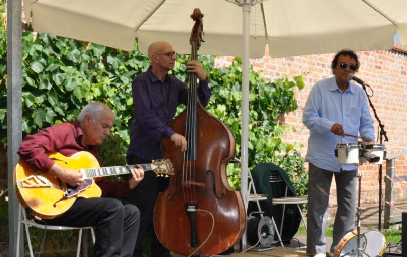 Drei Musiker auf einer Bühne im Garten