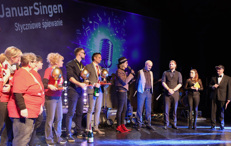 Gruppenfoto: Personen mit der goldenen Wruke bzw. mit Mikrofon in der Hand