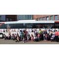Foto: Gruppenbild vor dem mit Kindermotiven gestalteten Linienbus.