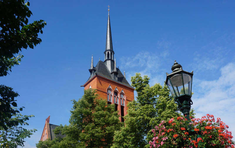 Foto: Turm der Kirche und Laterne mit Blumen