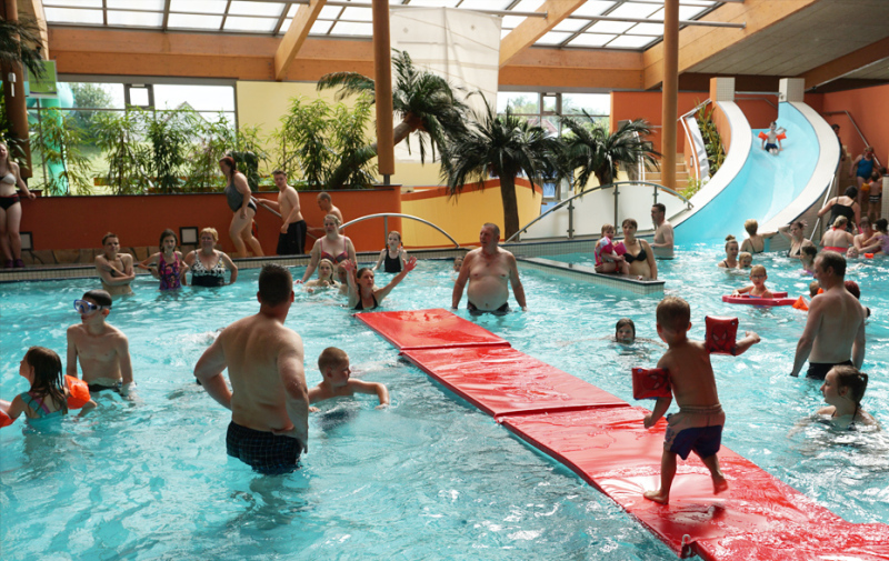 Foto: Kind läuft über Matten, die auf dem Wasser schwimmen