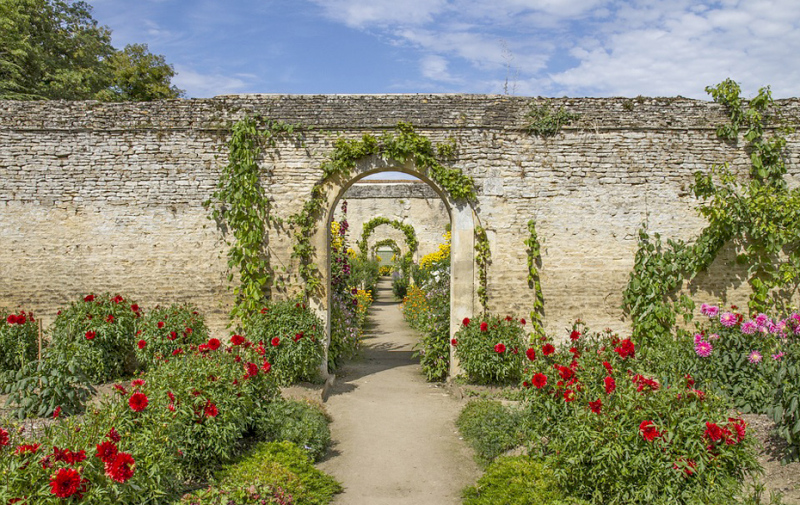 Foto: Gartenansicht mit Rundbogentor in einer Mauer