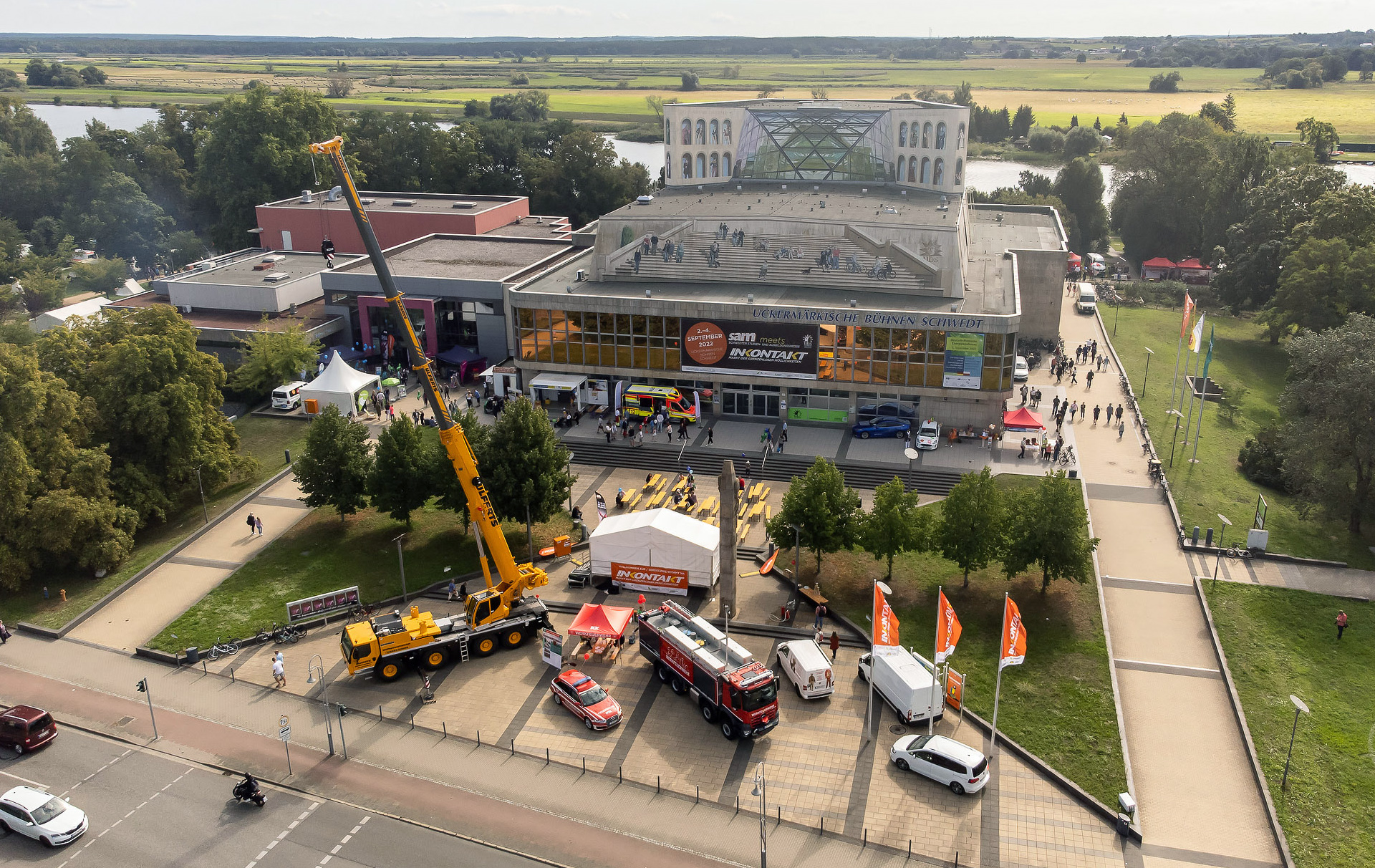 Luftbild: Theatervorplatz mit Fahrzeugen, Bühne, Ständen